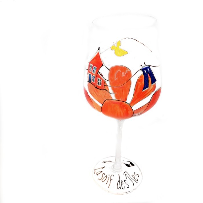 Un verre à vin avec d’une belle fleur peinte à la main ainsi qu’une maison croche inspirée par le vent des Îles-de-la-Madeleine. La soif des Îles. Le tout signé par l’artiste Carole Vigneau